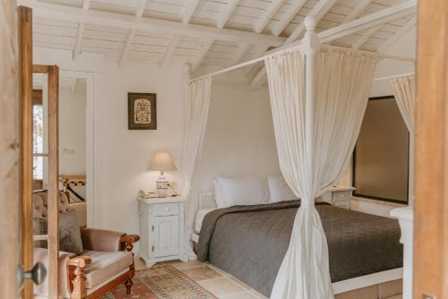 sypialnia z łóżkiem z baldachimem i krzesłem w obiekcie Çiy Restaurant & Konukevi w mieście Kusadası