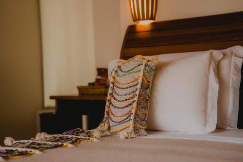 a bed with two pillows on top of it at Pousada Rangai in Maragogi
