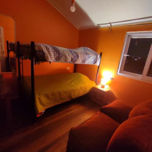 a bedroom with two bunk beds and a couch at Gatos de campo, tiernos y traviesos in Santiago