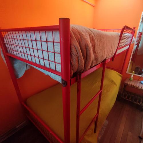 a red bunk bed in a small room at Gatos de campo, tiernos y traviesos in Santiago