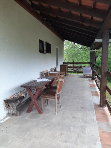 a patio with a wooden table and chairs at Ranch Farm Stay in Rakovica