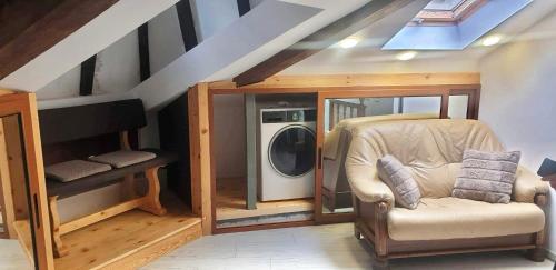 uma lavandaria com uma máquina de lavar roupa e uma cadeira em Lux Central Shumen Apartment em Shumen