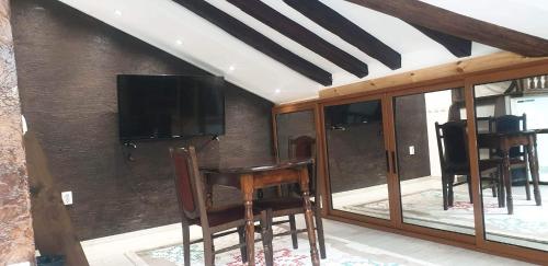 a room with a table and chairs and a television at Lux Central Shumen Apartment in Shumen