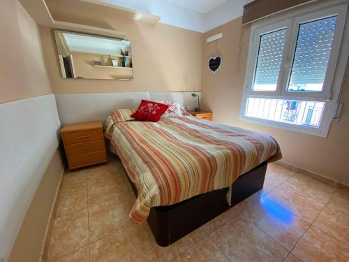 um pequeno quarto com uma cama e um espelho em Espectacular apartament a Palamós centre! Amb WIFI em Palamós