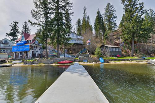 a dock in a body of water with houses at Huvila Haven Lake Front Home with Dock and Hot Tub in Newman Lake