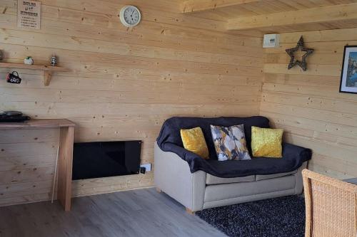 Habitación con silla, mesa y reloj en The Stunning Log House, en Wexford