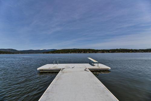 a dock in the middle of a body of water at Huvila Haven Lake Front Home with Dock and Hot Tub in Newman Lake
