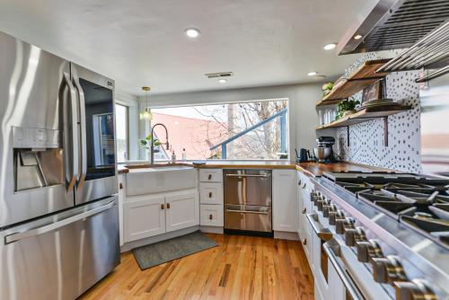 a kitchen with white appliances and a large window at Huvila Haven Lake Front Home with Dock and Hot Tub in Newman Lake