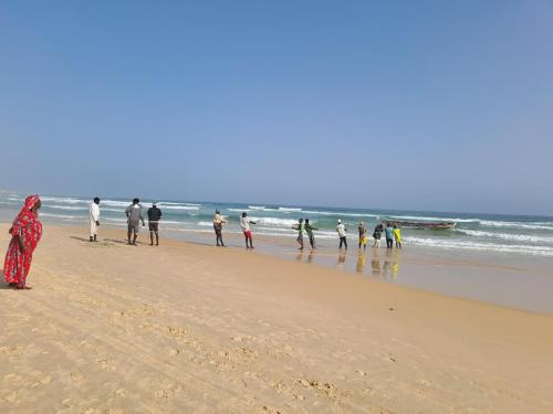 a group of people walking on the beach at Casa Djoko in Dakar