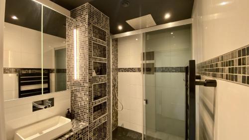 een badkamer met een wastafel en een douche bij Au refuge du matelot in Le Crotoy
