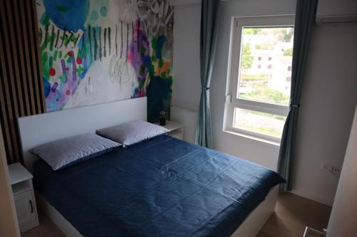 una camera con un letto blu e una finestra di Veronika a Fiume (Rijeka)