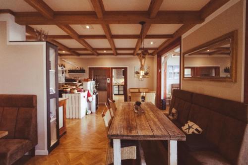 Il comprend un salon avec une table en bois et une cuisine. dans l'établissement Hotel Villa Schwanebeck, à Binz