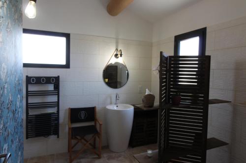 een badkamer met een bad, een wastafel en een spiegel bij Charmant appartement calme à Paradou in Paradou