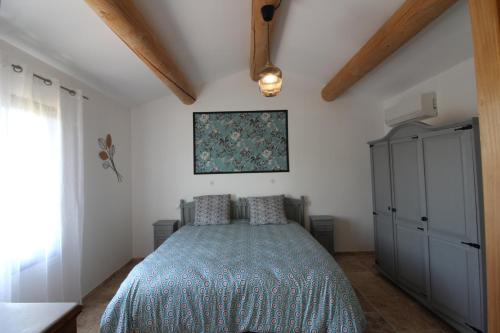 a bedroom with a bed with a blue blanket at Charmant appartement calme à Paradou in Paradou