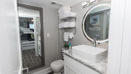 a white bathroom with a sink and a mirror at Total Remodel BEACHFRONT 5th Floor - 2 Bd & 2 Ba - Dunes of Panama in Panama City Beach