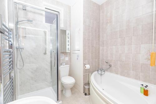 Un baño con bañera, inodoro y ducha. en Pier Top - Free all Island parking permit, en Ventnor