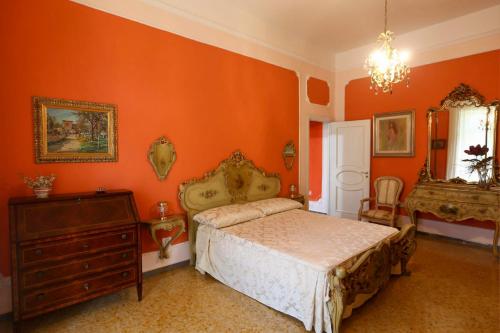 sypialnia z pomarańczowymi ścianami, łóżkiem i komodą w obiekcie La Vie En Rose w mieście Cava deʼ Tirreni
