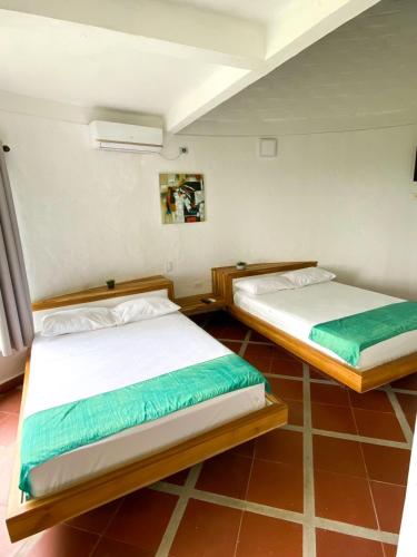 two twin beds in a room with at La Manola Finca Hotel in Doradal