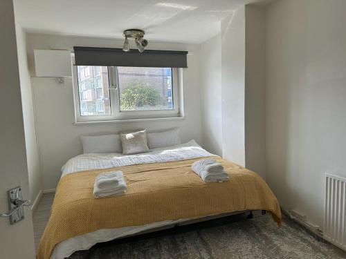 a small bedroom with a bed with a window at Cheerful double room for single use in London
