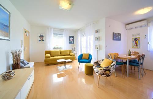 sala de estar con sofá amarillo y mesa en Apartman Noel, en Krk
