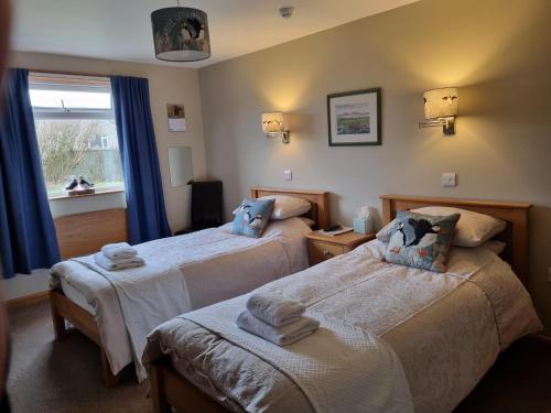 Habitación de hotel con 2 camas y ventana en Bellavista Guest House en Kirkwall