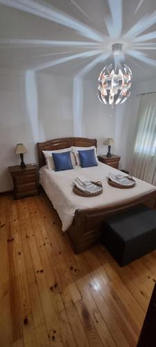 Un dormitorio con una cama grande y una lámpara de araña. en Casa do Espadanal en Vila Real