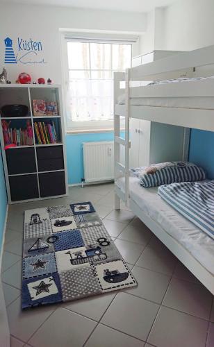 a bedroom with a bunk bed and a rug on the floor at Strukkamp "Inselmädchen" Strukkamp in Fehmarn