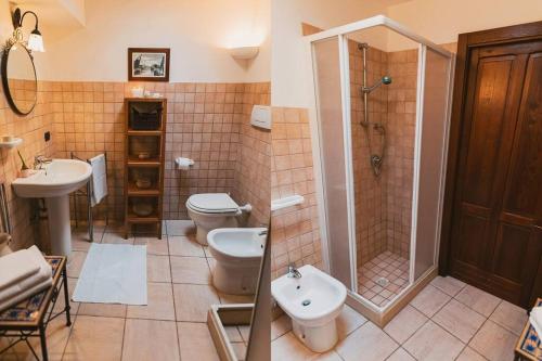 uma casa de banho com um WC, um chuveiro e um lavatório. em Trulli Di Nonno Stefano em Locorotondo