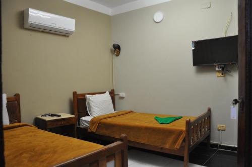 a small room with two beds and a tv at Dahab Plaza Hotel in Dahab