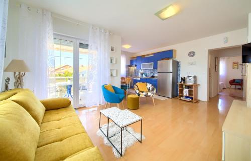 sala de estar con sofá amarillo y cocina en Apartman Noel, en Krk