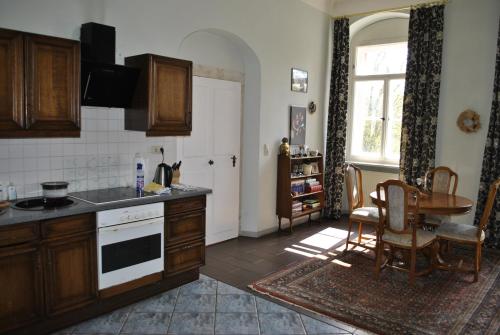 uma cozinha com armários de madeira, uma mesa e uma janela em Schloss Triestewitz em Arzberg