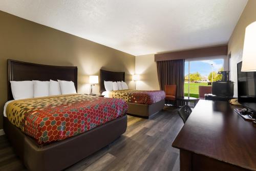 Habitación de hotel con 2 camas y escritorio en Econo Lodge - Perry National Fair Ground Area, en Perry