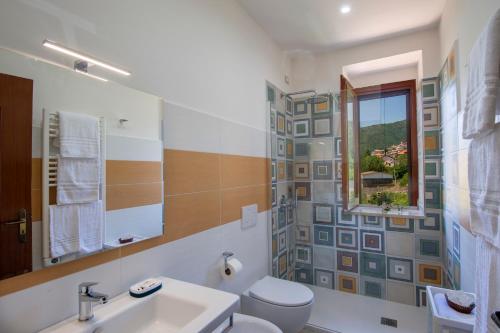a bathroom with a sink and a toilet and a window at I colori della Luna in Agerola