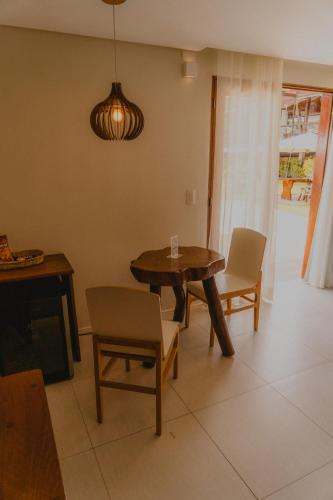 a living room with a wooden table and chairs at Pousada Rangai in Maragogi