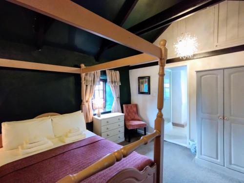 StithiansにあるTrethellan Viewのベッドルーム(天蓋付きベッド1台、椅子付)