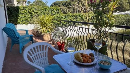 une table avec une assiette de nourriture et des verres de vin dans l'établissement Bel appartement avec grande terrasse ensoleillée et jardin, à Perpignan