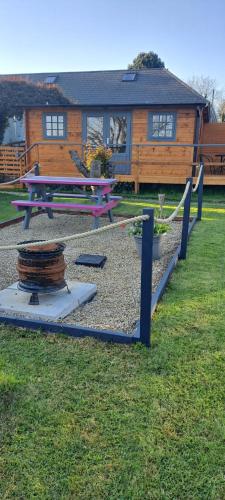 a park with a picnic table and a house at The Stunning Log House in Wexford