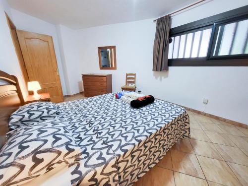 a bedroom with a bed with a black and white comforter at parque royale 1 in Adeje