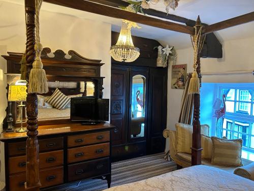 a bedroom with a bed and a dresser with a television at 8 Opera Suites, Llangollen in Llangollen