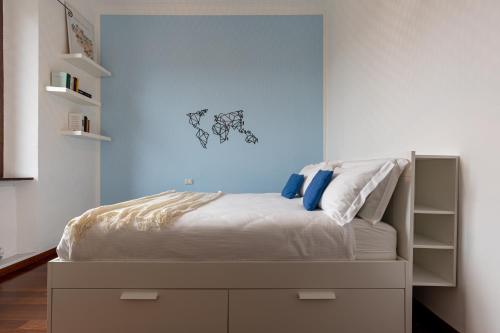 um quarto com uma cama com uma parede azul em BePlace Apartments in Lotto em Milão