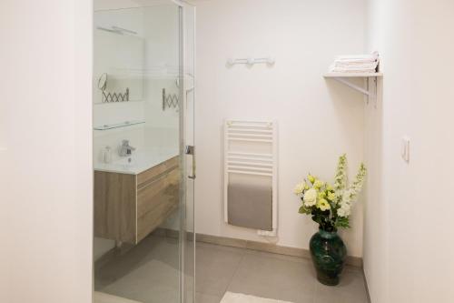une salle de bain avec un lavabo et un vase de fleurs dans l'établissement Barbara's Apartment Carry le Rouet, à Carry-le-Rouet