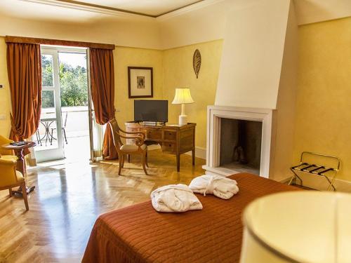 a bedroom with a bed with a fireplace and a desk at Relais Villa San Martino in Martina Franca