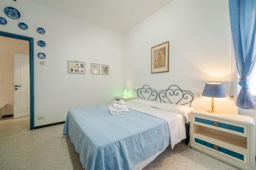 um quarto com uma cama e uma mesa com um candeeiro em INTO THE BLUE Lavagna Seaside Flat em Lavagna
