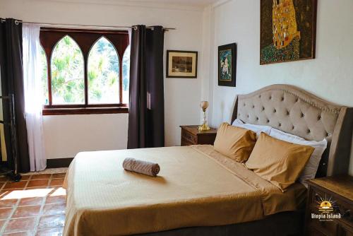 a bedroom with a large bed with a large window at Utopia Island Resort in Batangas City