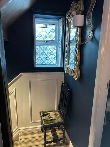 a blue room with a chair and a window at 8 Opera Suites, Llangollen in Llangollen