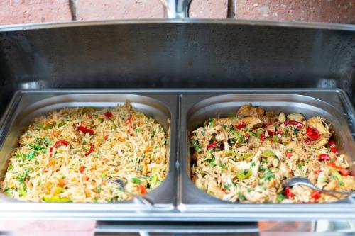 two metal trays of food in a stove at Elea Old Tbilisi Hotel in Tbilisi City