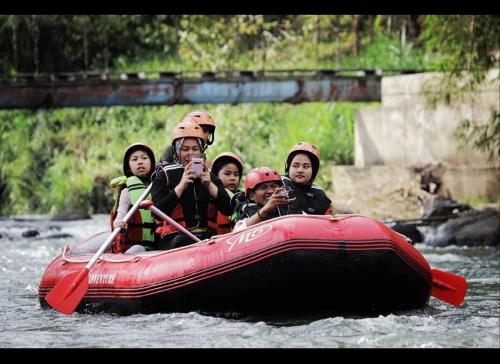 a group of people in a raft on a river at Rumah Gadang Tokama, Simarasok in Baso