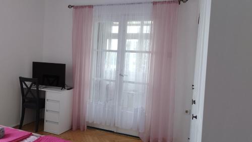 1 dormitorio con una ventana con cortinas rosas en Apolonija, en Rijeka