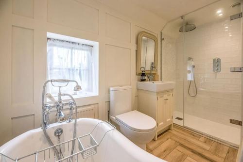 a bathroom with a tub and a toilet and a sink at Lantern Cottage in Stowmarket