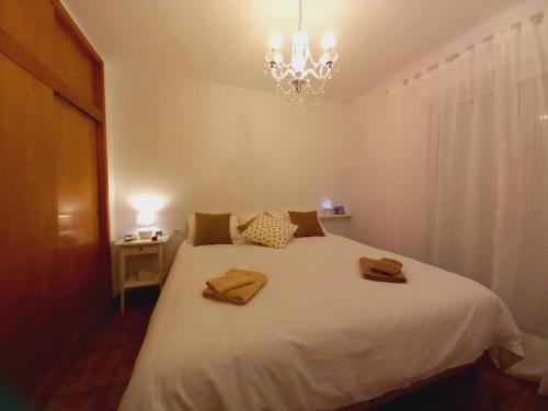 a bedroom with a large white bed with a chandelier at Rincón de Encanto a Paso del Mar in Altea
